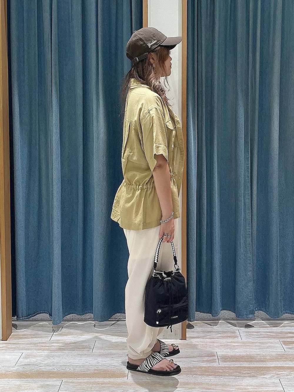 ベージュ系のその他パンツ、イエロー系のシャツ/ブラウス、ブラック系のショルダーバッグを着用したレディースの夏コーディネートの2枚目の写真