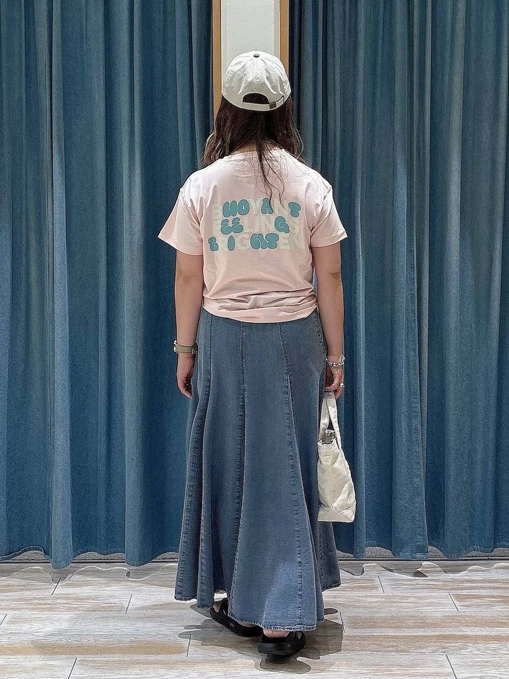 ピンク系のTシャツ/カットソー、ブルー系のスカート、ブラック系のサンダルを着用したレディースの夏コーディネートの3枚目の写真
