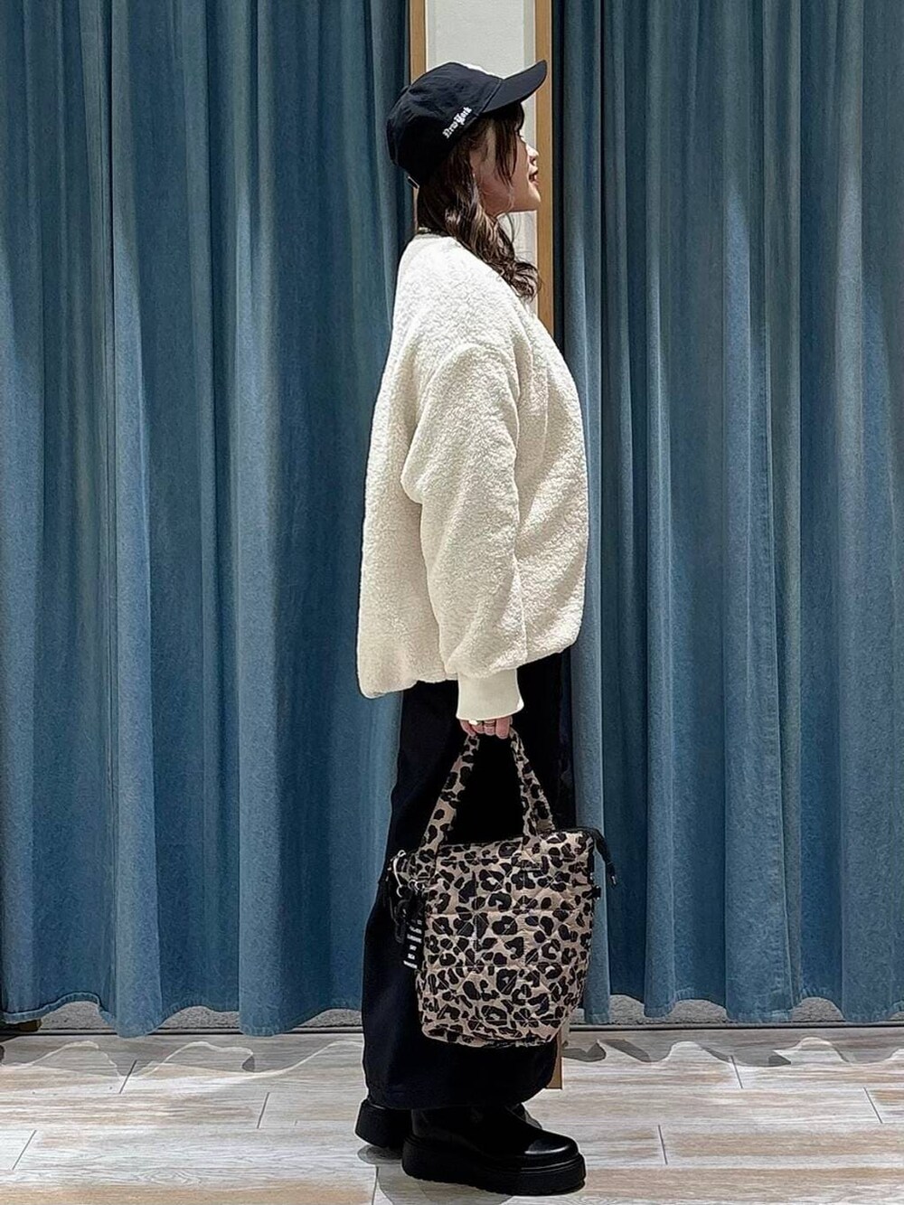 ブラック系のスカート、ブラック系のブーツ、ブラック系のブルゾンを着用したレディースの冬コーディネートの2枚目の写真