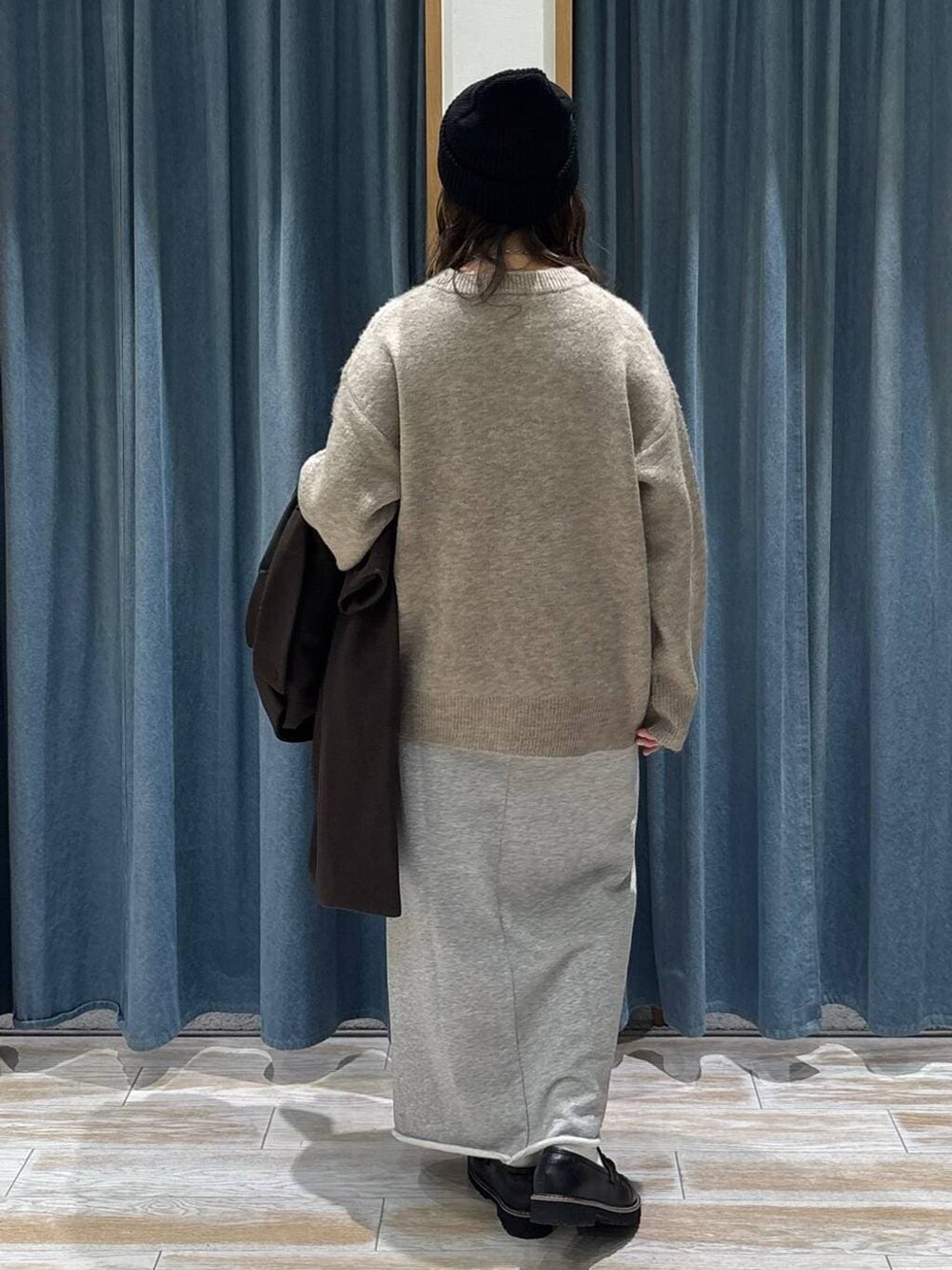 ブラウン系のチェスターコート、ブラック系のローファー、ブラウン系のニット/セーターを着用したレディースの冬コーディネートの3枚目の写真