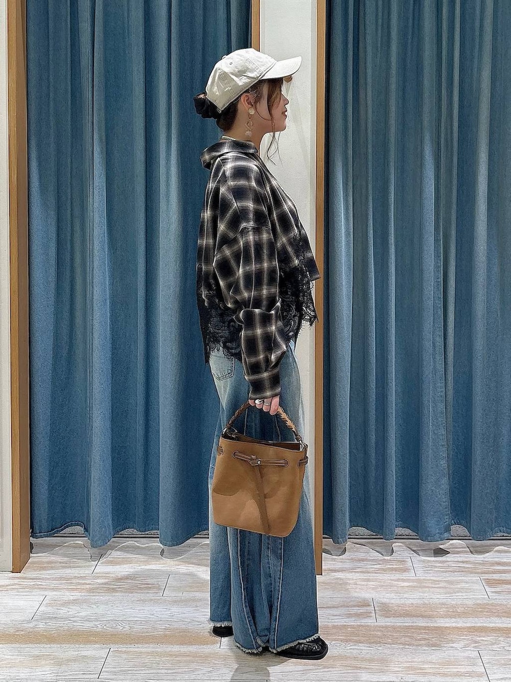 ブラック系のスリッポン、ブルー系のデニムパンツ、ブラウン系のシャツ/ブラウスを着用したレディースの夏コーディネートの2枚目の写真