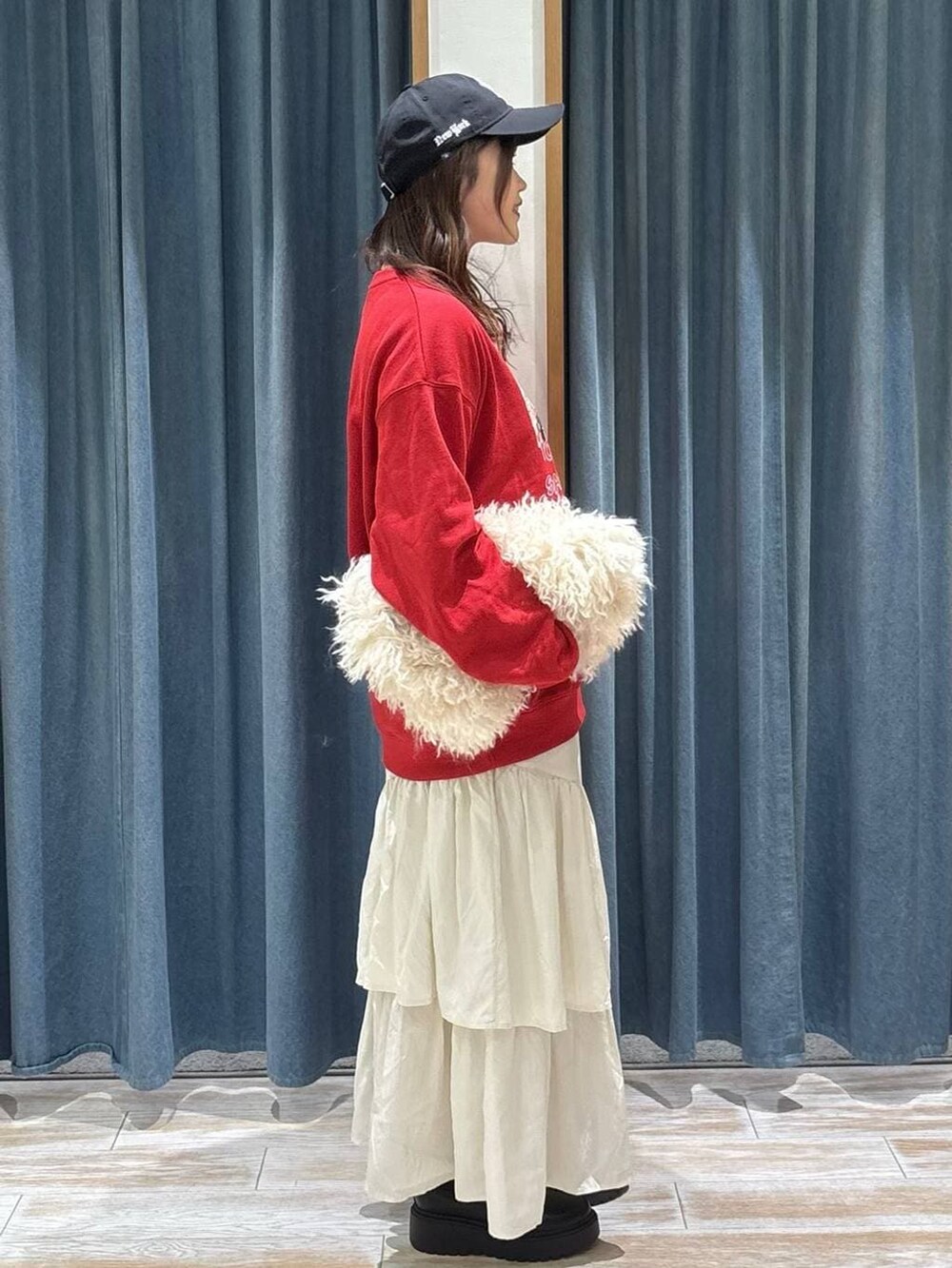 ブラック系のブーツ、ベージュ系のスカート、ベージュ系のショルダーバッグを着用したレディースの冬コーディネートの2枚目の写真