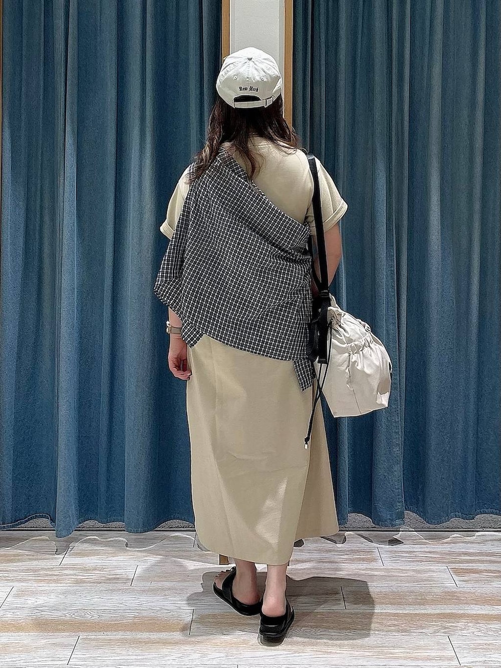 ホワイト系のトートバッグ、ブラック系のサンダル、ブルー系のシャツ/ブラウスを着用したレディースの春コーディネートの3枚目の写真