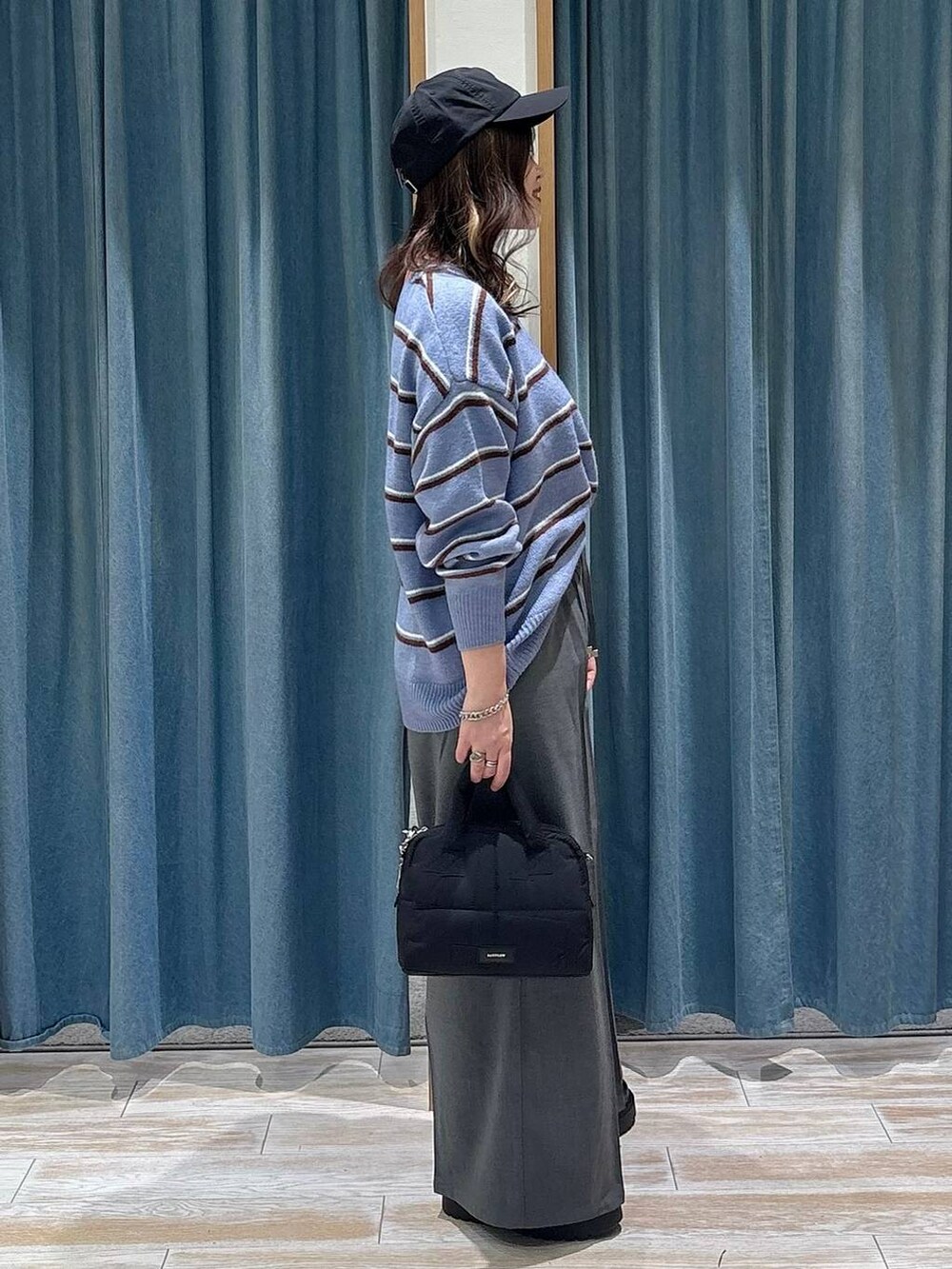 グレー系のその他パンツ、ブラック系のブーツ、ブラック系のボストンバッグを着用したレディースの冬コーディネートの2枚目の写真