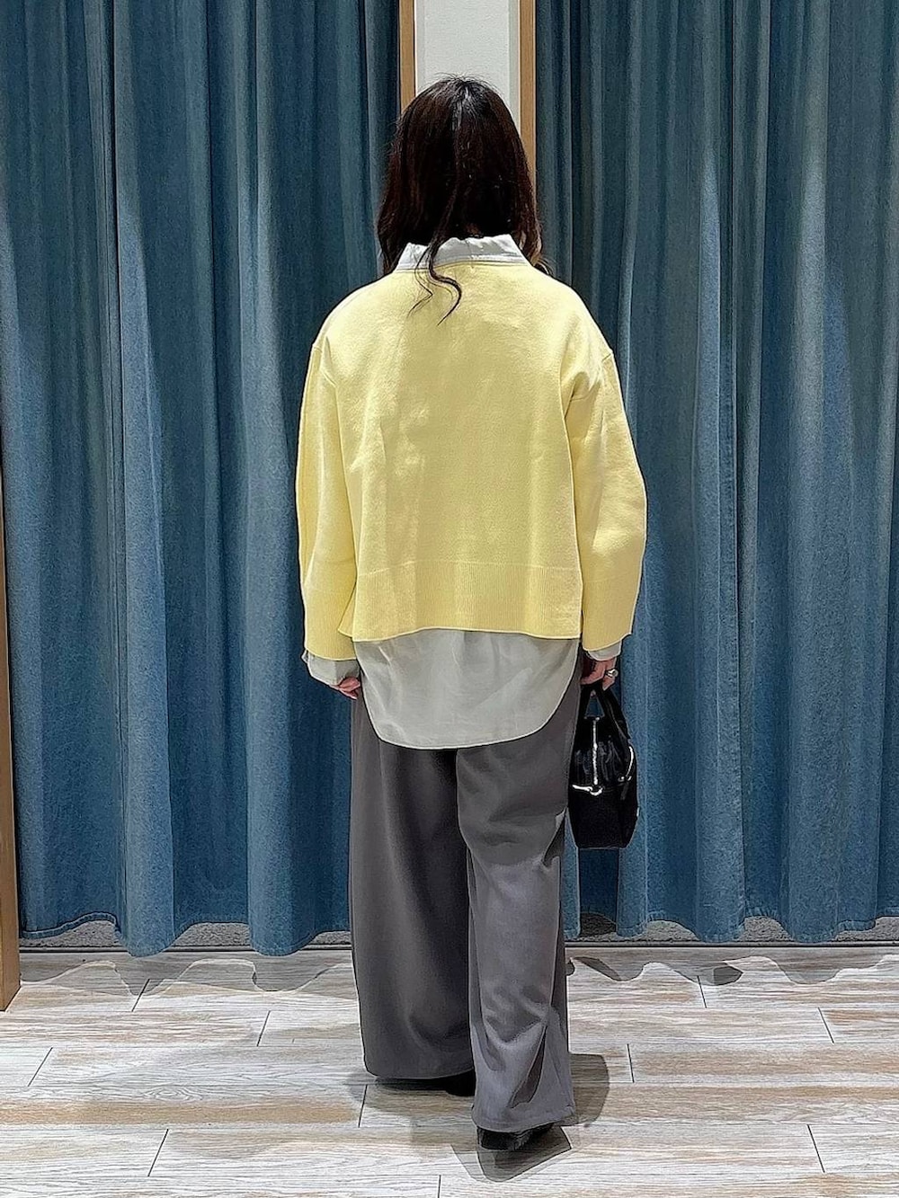 グレー系のシャツ/ブラウス、ブラック系のハンドバッグ、イエロー系のニット/セーターを着用したレディースの冬コーディネートの3枚目の写真