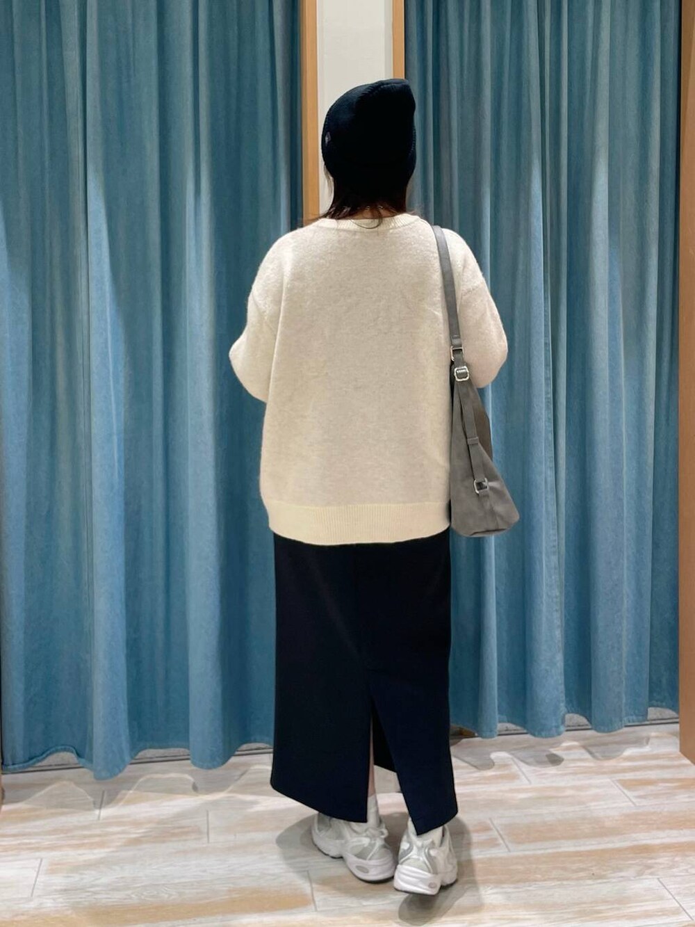 グレー系のショルダーバッグ、ホワイト系のニット/セーター、ブラック系のスカートを着用したレディースの冬コーディネートの3枚目の写真