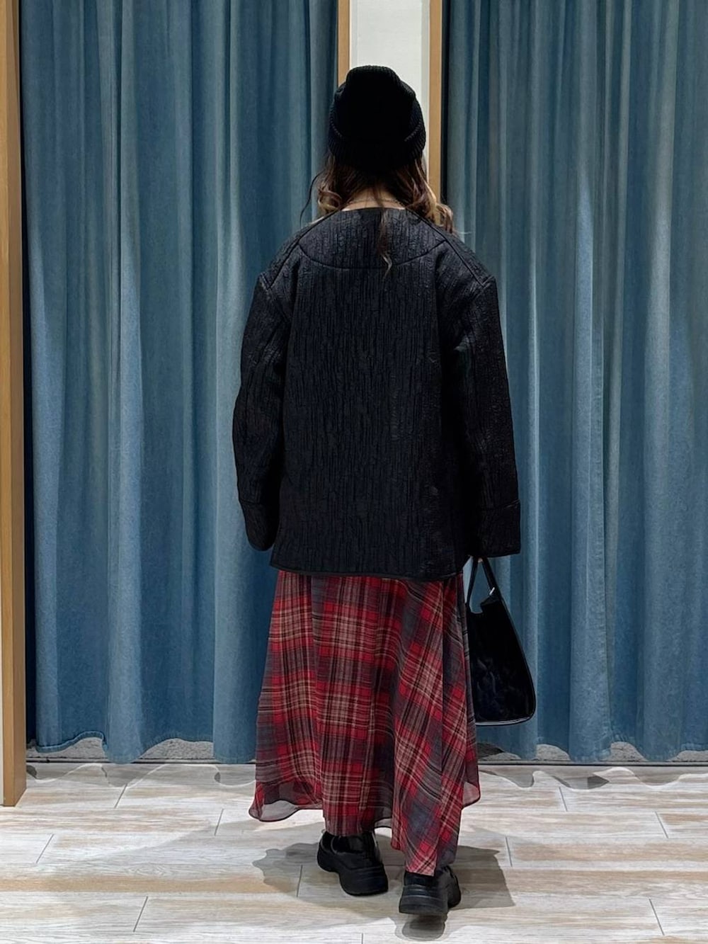 ブラック系のブーツ、ブラック系のハンドバッグ、ブラック系のブルゾンを着用したレディースの秋コーディネートの3枚目の写真