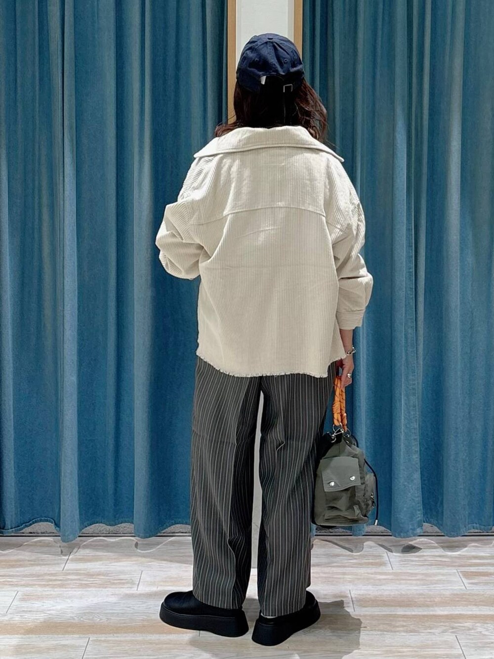 ブラック系のTシャツ/カットソー、ブラック系のサンダル、グリーン系のハンドバッグを着用したレディースの秋コーディネートの3枚目の写真