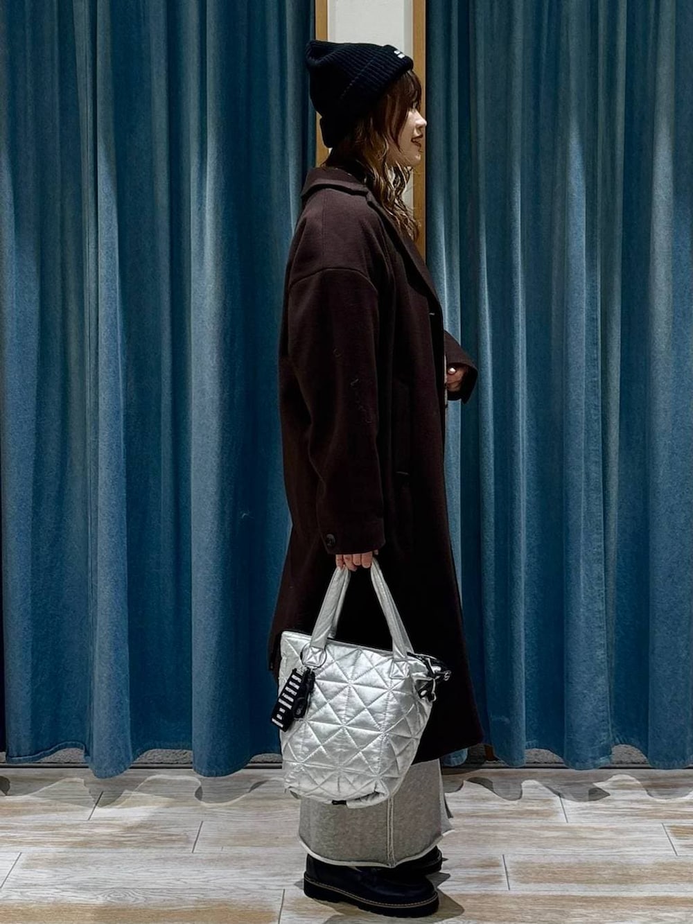 ブラウン系のチェスターコート、ブラック系のローファー、ブラウン系のニット/セーターを着用したレディースの冬コーディネートの2枚目の写真