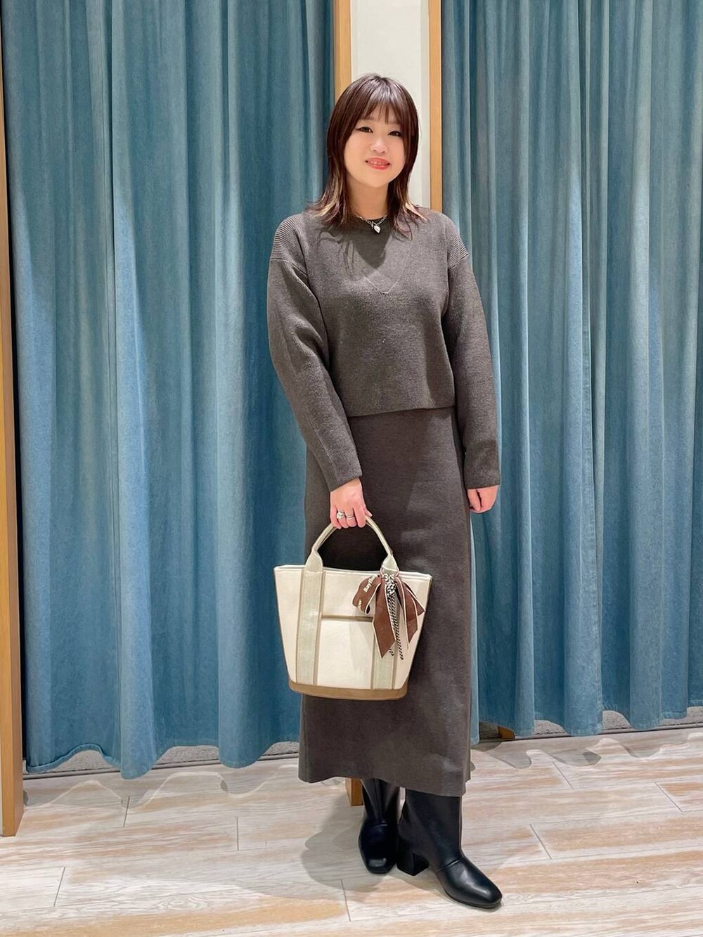 ホワイト系のダウンジャケット/コート、ブラック系のブーツ、ホワイト系のトートバッグを着用したレディースの冬コーディネートの4枚目の写真