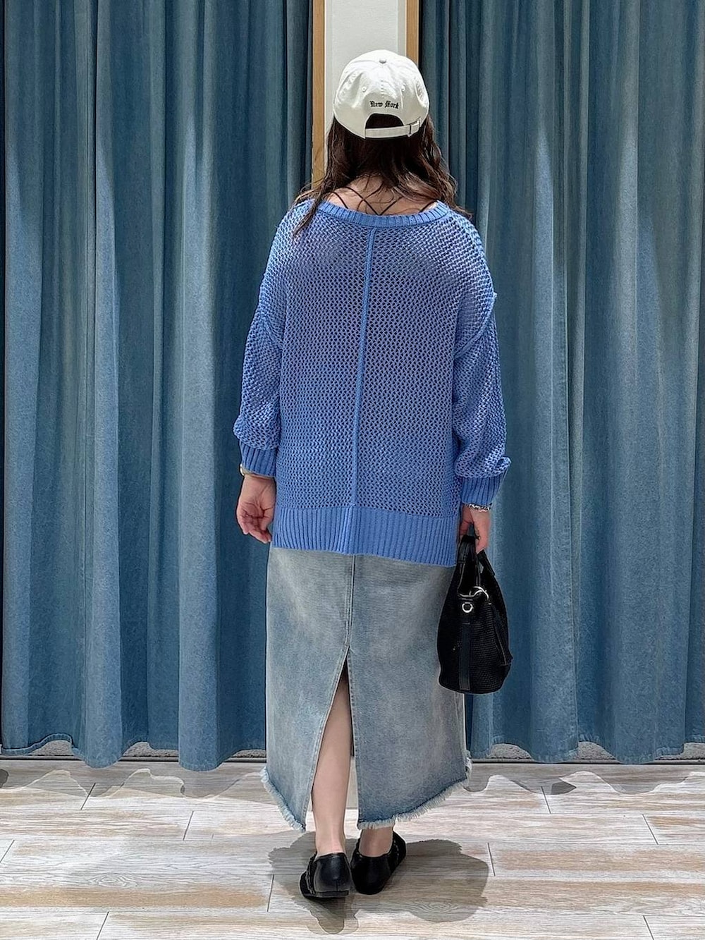 ブルー系のデニムスカート、ブラック系のショルダーバッグ、ブラック系のパンプスを着用したレディースの春コーディネートの3枚目の写真