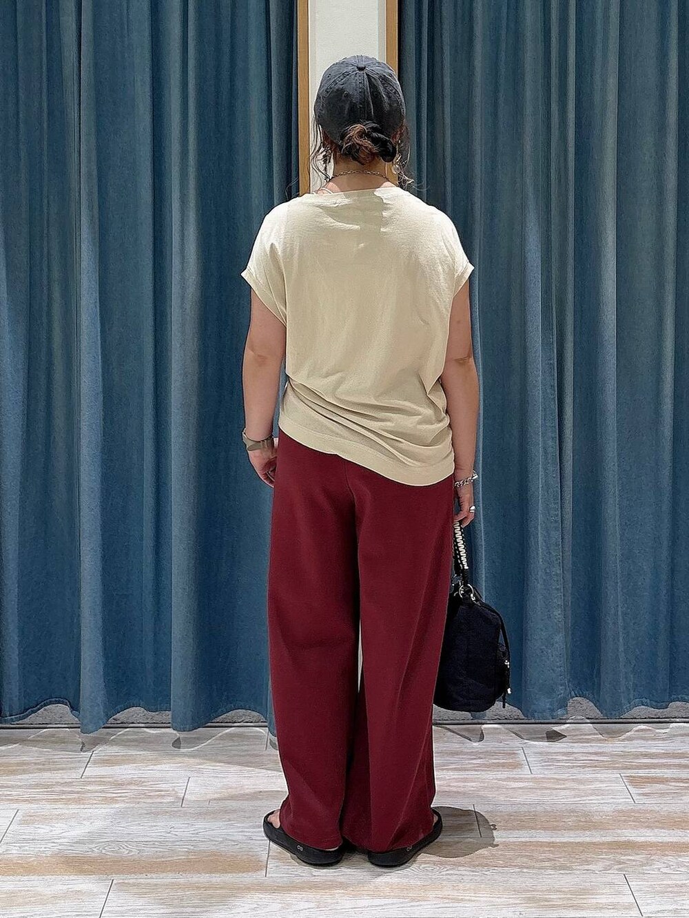 ベージュ系のTシャツ/カットソー、レッド系のスウェットパンツ、ブラック系のショルダーバッグを着用したレディースの夏コーディネートの4枚目の写真
