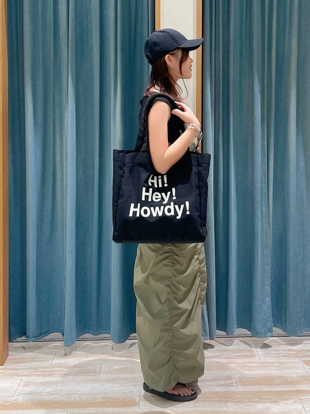 ブルー系のキャミソール、グリーン系のスカート、ブラック系のサンダルを着用したレディースの春コーディネートの2枚目の写真