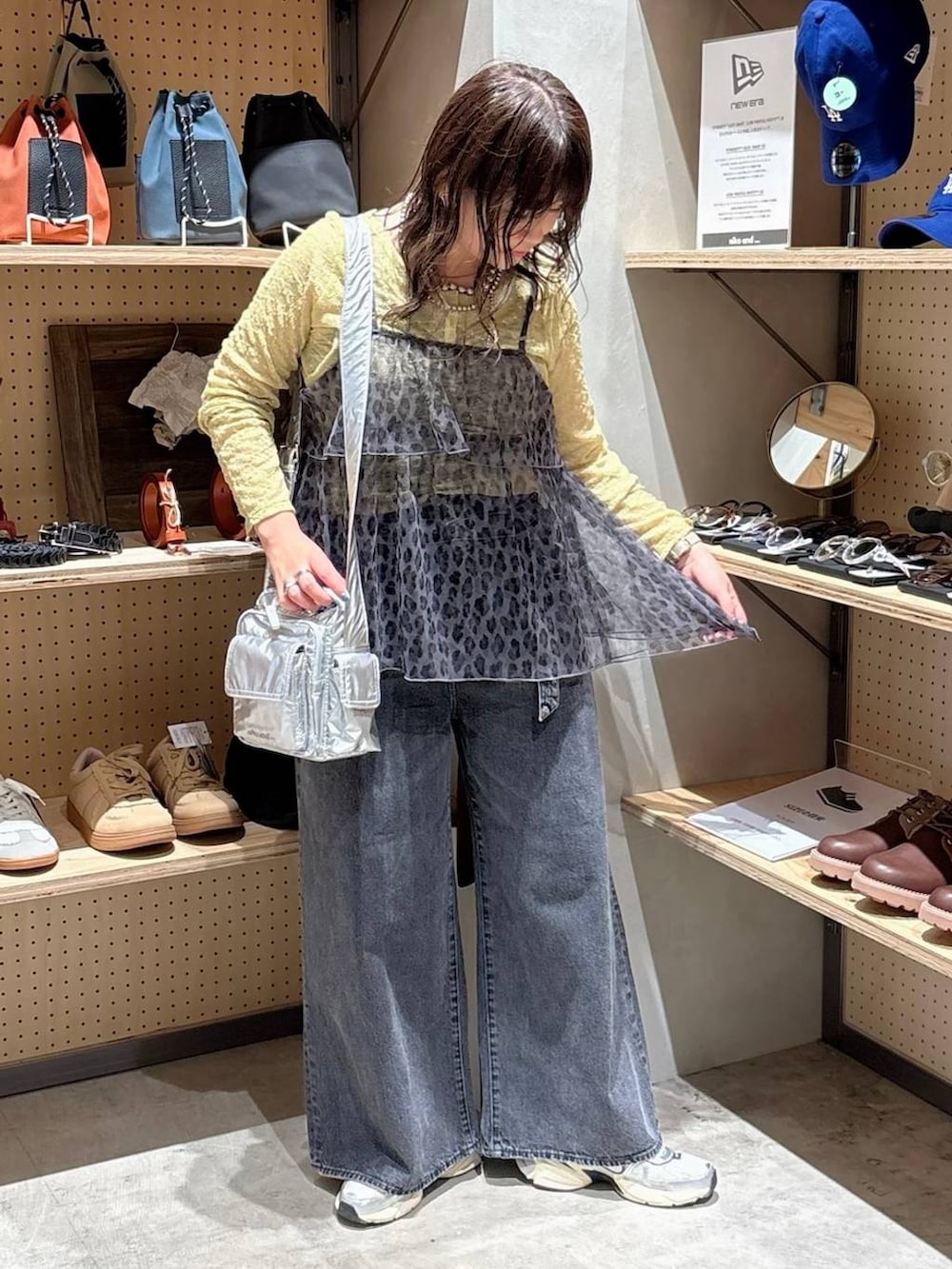 シルバー系のショルダーバッグ、イエロー系のTシャツ/カットソー、グレー系のデニムパンツを着用したレディースの秋コーディネートの2枚目の写真