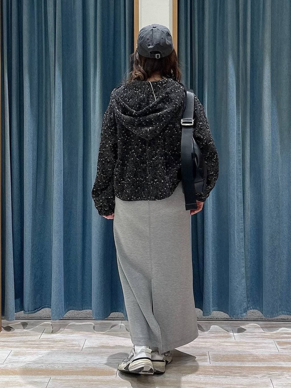 ブラック系のショルダーバッグ、ブラック系のブルゾン、グレー系のワンピースを着用したレディースの春コーディネートの3枚目の写真