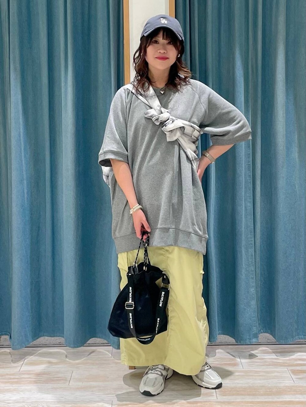 ブラック系のショルダーバッグ、ホワイト系のスニーカー、ホワイト系のシャツ/ブラウスを着用したレディースの春コーディネートの4枚目の写真