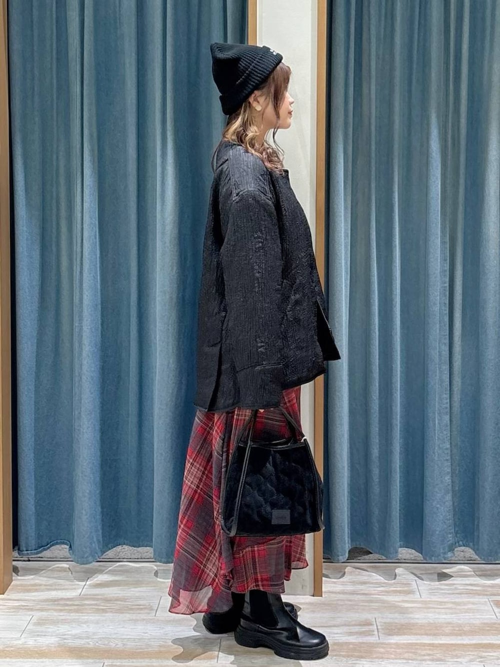 ブラック系のブーツ、ブラック系のハンドバッグ、ブラック系のブルゾンを着用したレディースの秋コーディネートの2枚目の写真