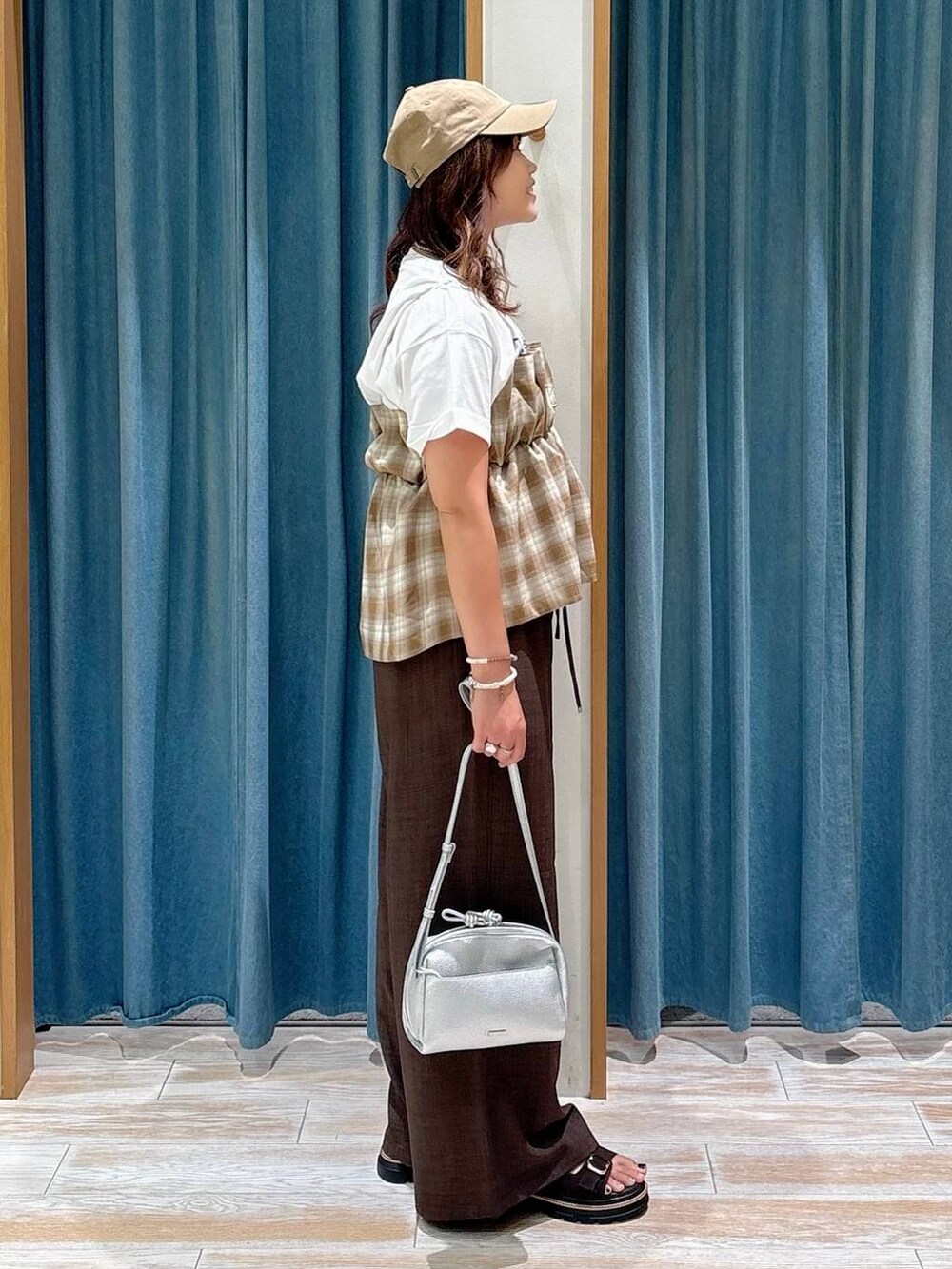 ホワイト系のTシャツ/カットソー、ブラウン系のサンダル、シルバー系のショルダーバッグを着用したレディースの夏コーディネートの2枚目の写真