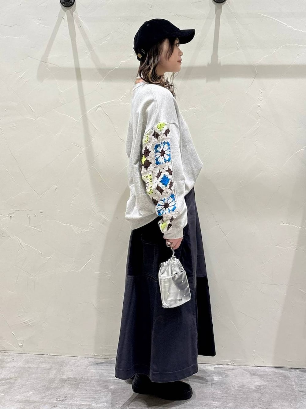 シルバー系のショルダーバッグ、グレー系のスウェット、グレー系のスカートを着用したレディースの冬コーディネートの2枚目の写真