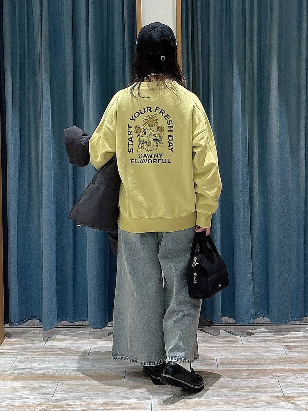 グレー系のダウンジャケット/コート、ブラック系のローファー、ブラック系のボストンバッグを着用したレディースの冬コーディネートの3枚目の写真