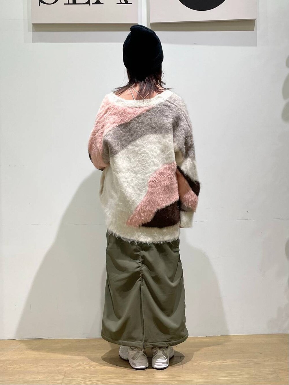 グリーン系のスカート、ホワイト系のカーディガン/ボレロ、ホワイト系のキャミソールを着用したレディースの秋コーディネートの2枚目の写真