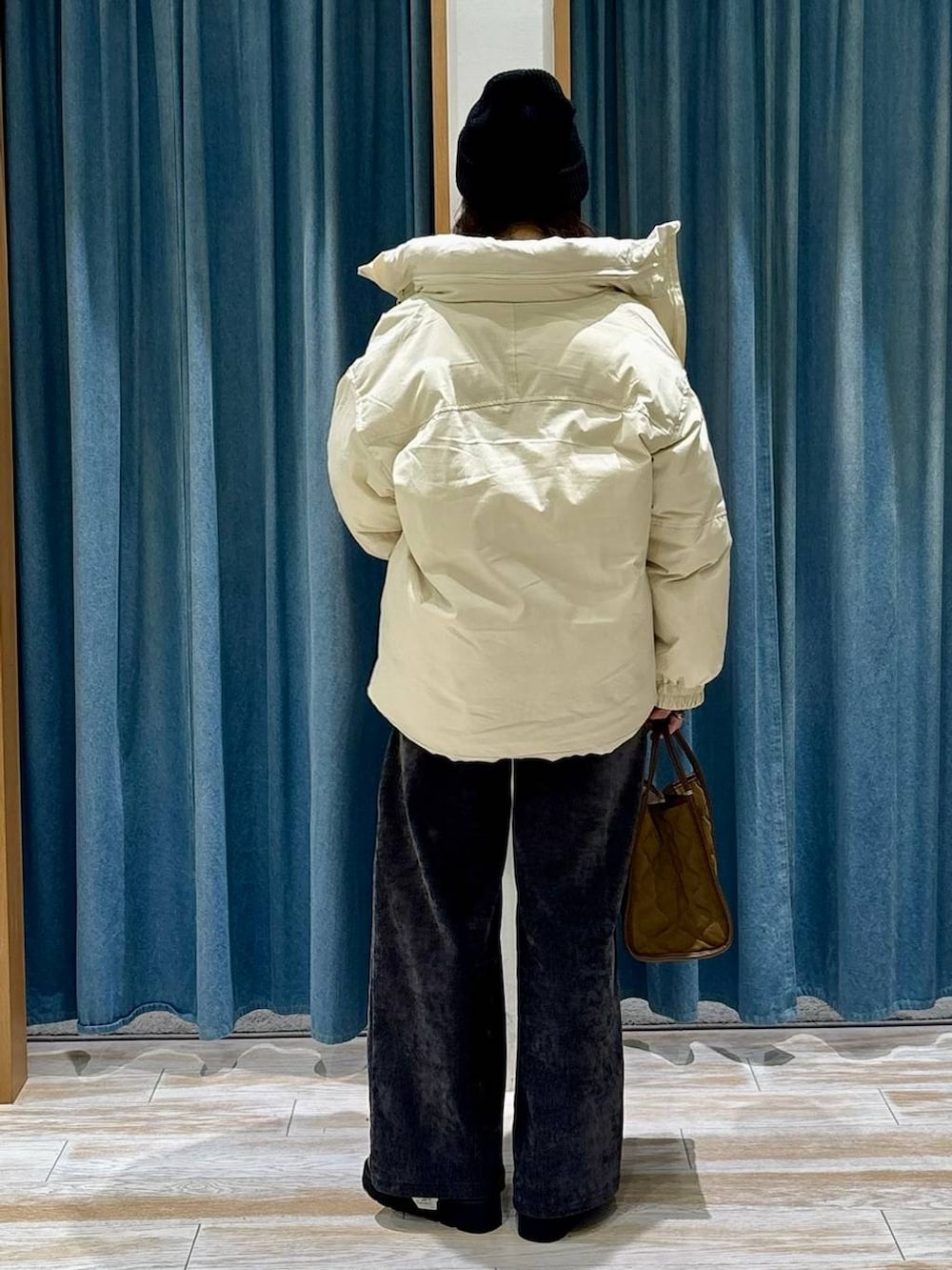 レッド系のニット/セーター、ホワイト系のダウンジャケット/コート、イエロー系のハンドバッグを着用したレディースの秋コーディネートの3枚目の写真