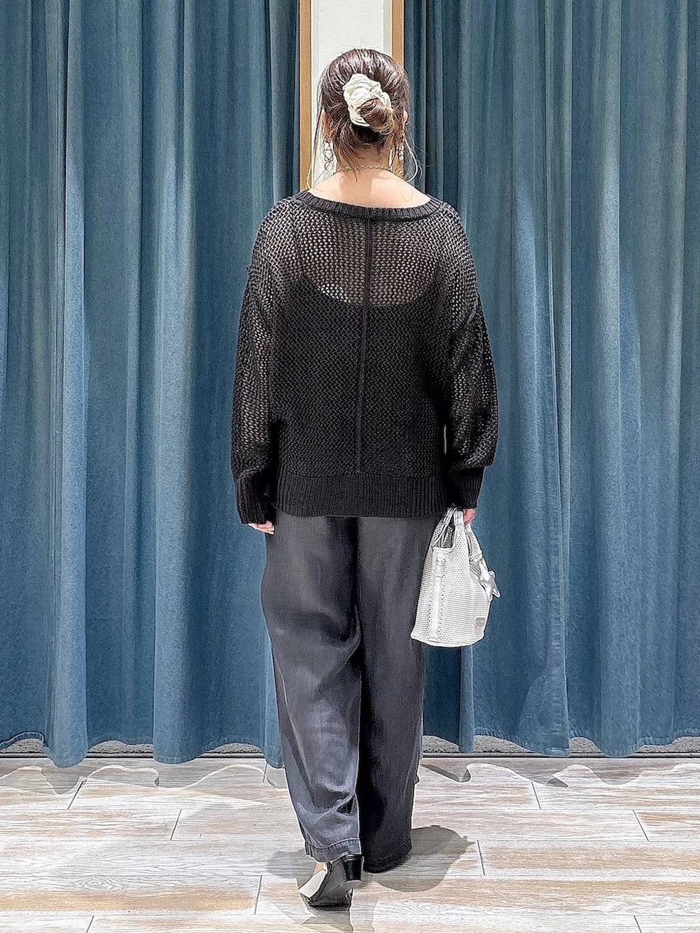 ブラック系のデニムパンツ、グレー系のショルダーバッグ、ブラック系のサンダルを着用したレディースの春コーディネートの3枚目の写真