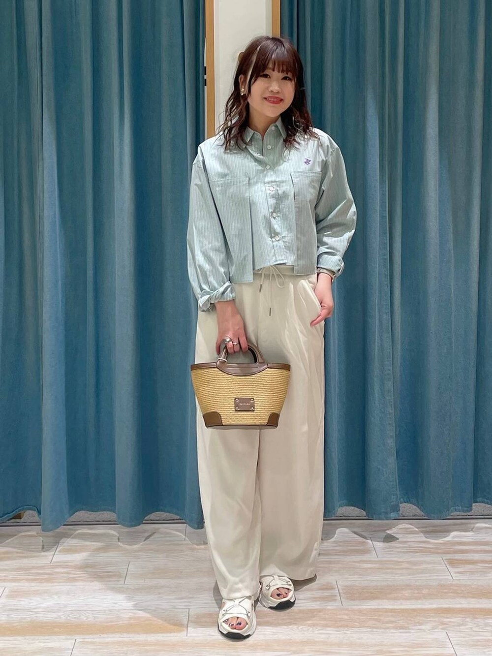 ホワイト系のその他パンツ、ホワイト系のサンダル、ブラウン系のショルダーバッグを着用したレディースの春コーディネートの4枚目の写真