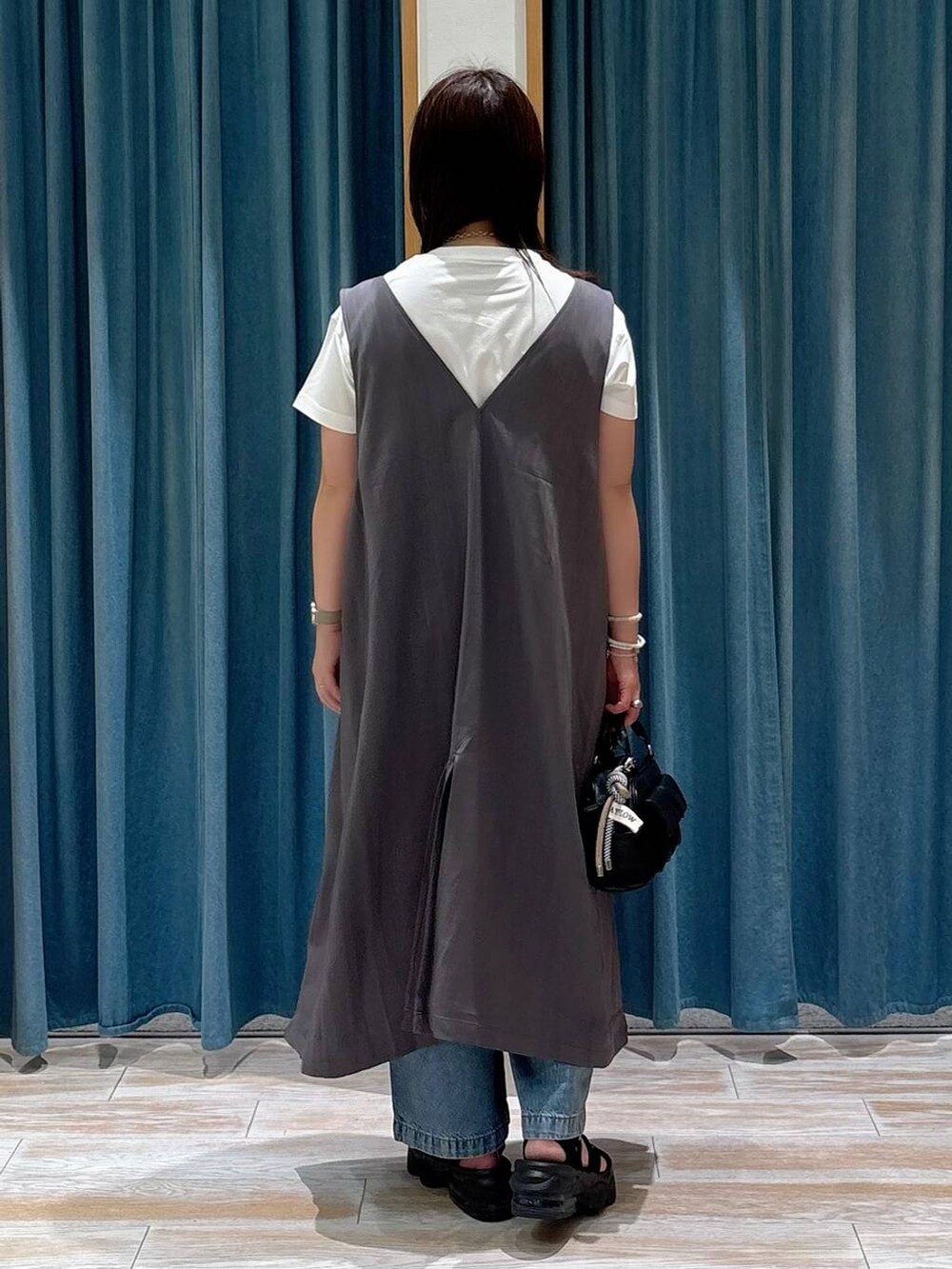 ホワイト系のTシャツ/カットソー、ブルー系のデニムパンツ、ブラック系のボストンバッグを着用したレディースの夏コーディネートの2枚目の写真