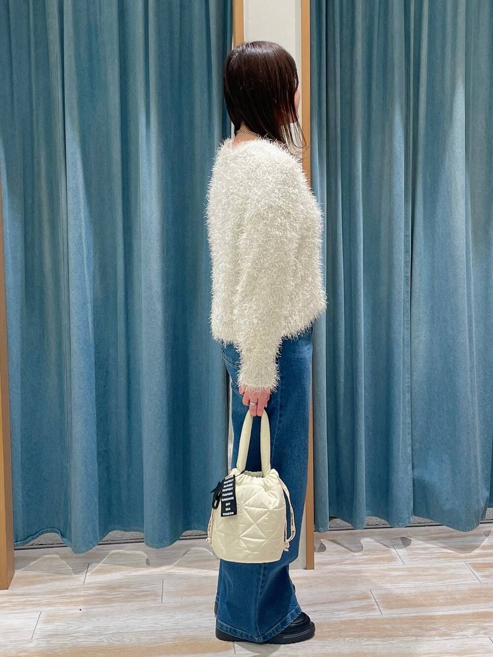 ホワイト系のニット/セーター、その他のローファー、ベージュ系のショルダーバッグを着用したレディースの冬コーディネートの2枚目の写真