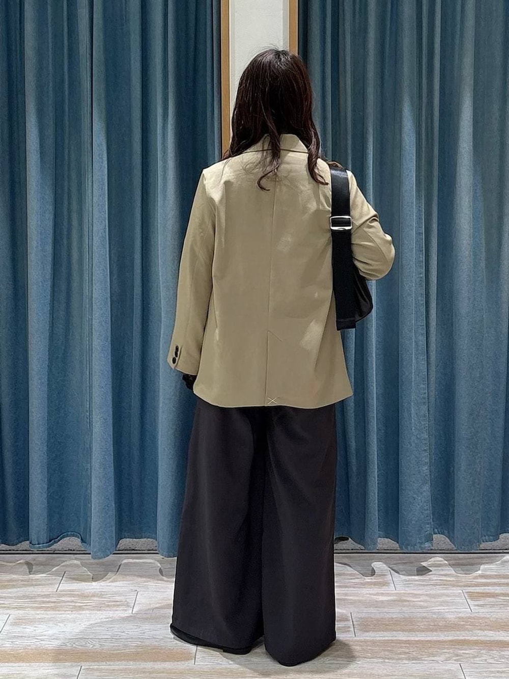 ブラック系のTシャツ/カットソー、ブラック系のローファー、ベージュ系のテーラードジャケットを着用したレディースの冬コーディネートの3枚目の写真