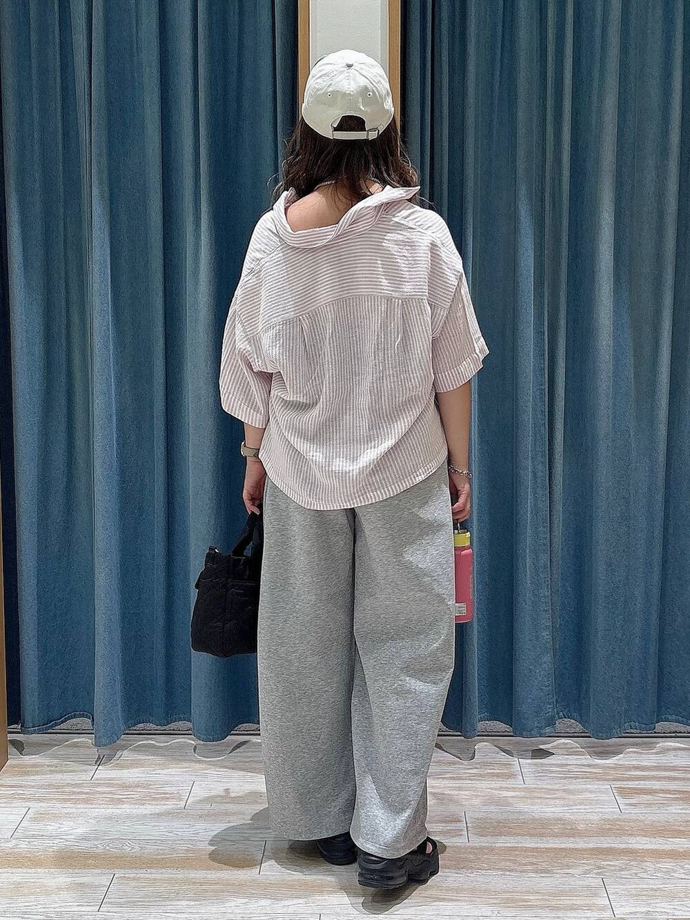 グレー系のスウェットパンツ、ブラック系のハンドバッグ、グレー系のブレスレットを着用したレディースの夏コーディネートの3枚目の写真