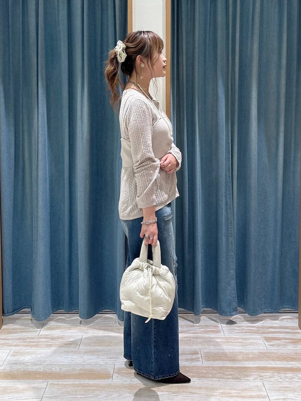 ブラウン系のパンプス、ブルー系のデニムパンツ、ベージュ系のニット/セーターを着用したレディースの秋コーディネートの2枚目の写真