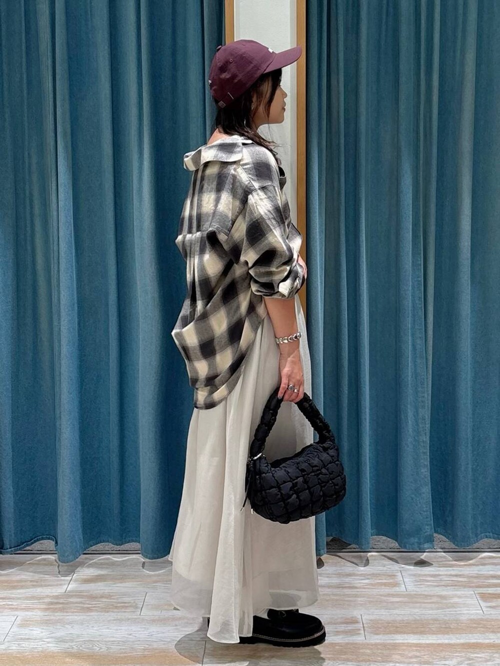 ホワイト系のスカート、ベージュ系のシャツ/ブラウス、ブラック系のハンドバッグを着用したレディースの秋コーディネートの2枚目の写真