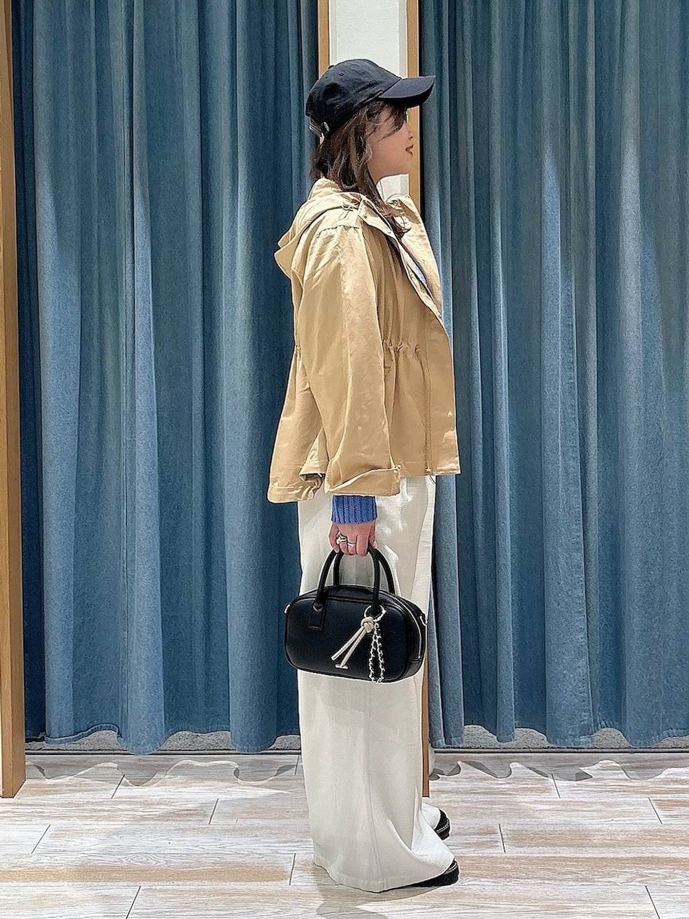 イエロー系のマウンテンパーカー、ブラック系のローファー、ブラック系のハンドバッグを着用したレディースの春コーディネートの2枚目の写真