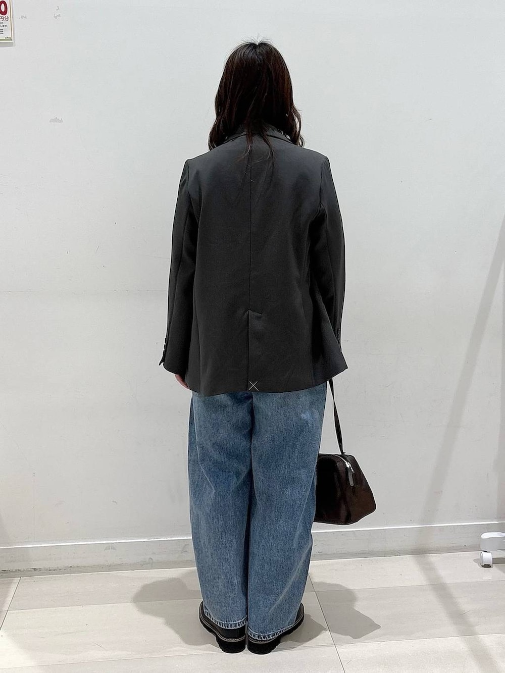 ブラック系のTシャツ/カットソー、ブルー系のデニムパンツ、グレー系のテーラードジャケットを着用したレディースの冬コーディネートの3枚目の写真