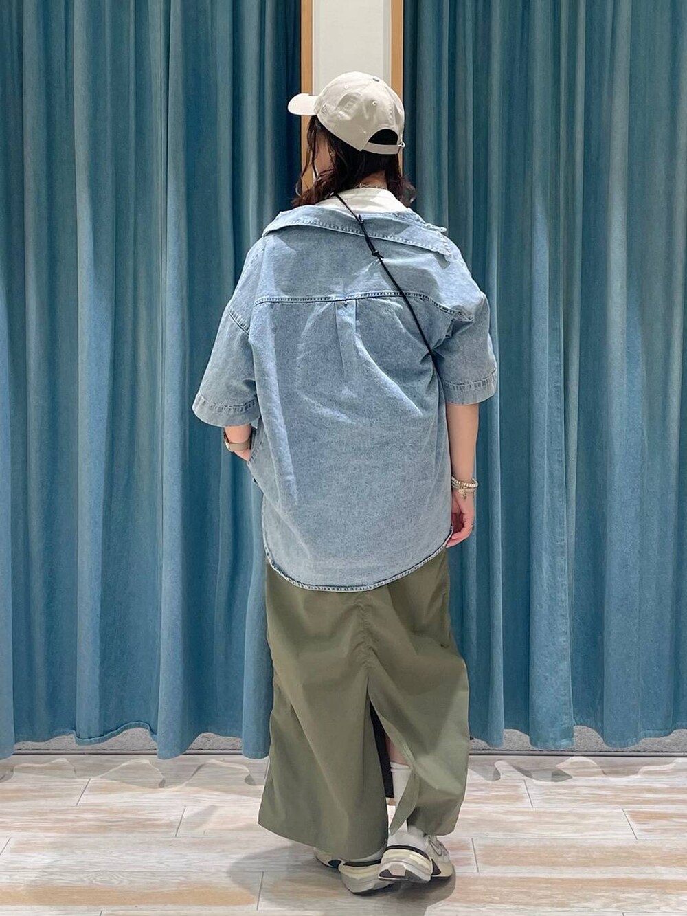 ホワイト系のTシャツ/カットソー、グリーン系のスカート、ブルー系のシャツ/ブラウスを着用したレディースの春コーディネートの2枚目の写真