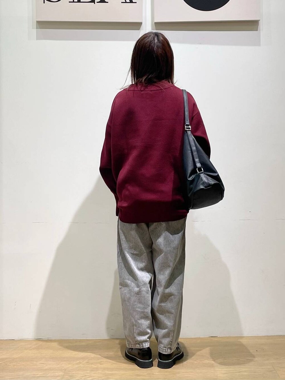 ブラック系のローファー、レッド系のニット/セーター、ブラック系のデニムパンツを着用したレディースの秋コーディネートの3枚目の写真