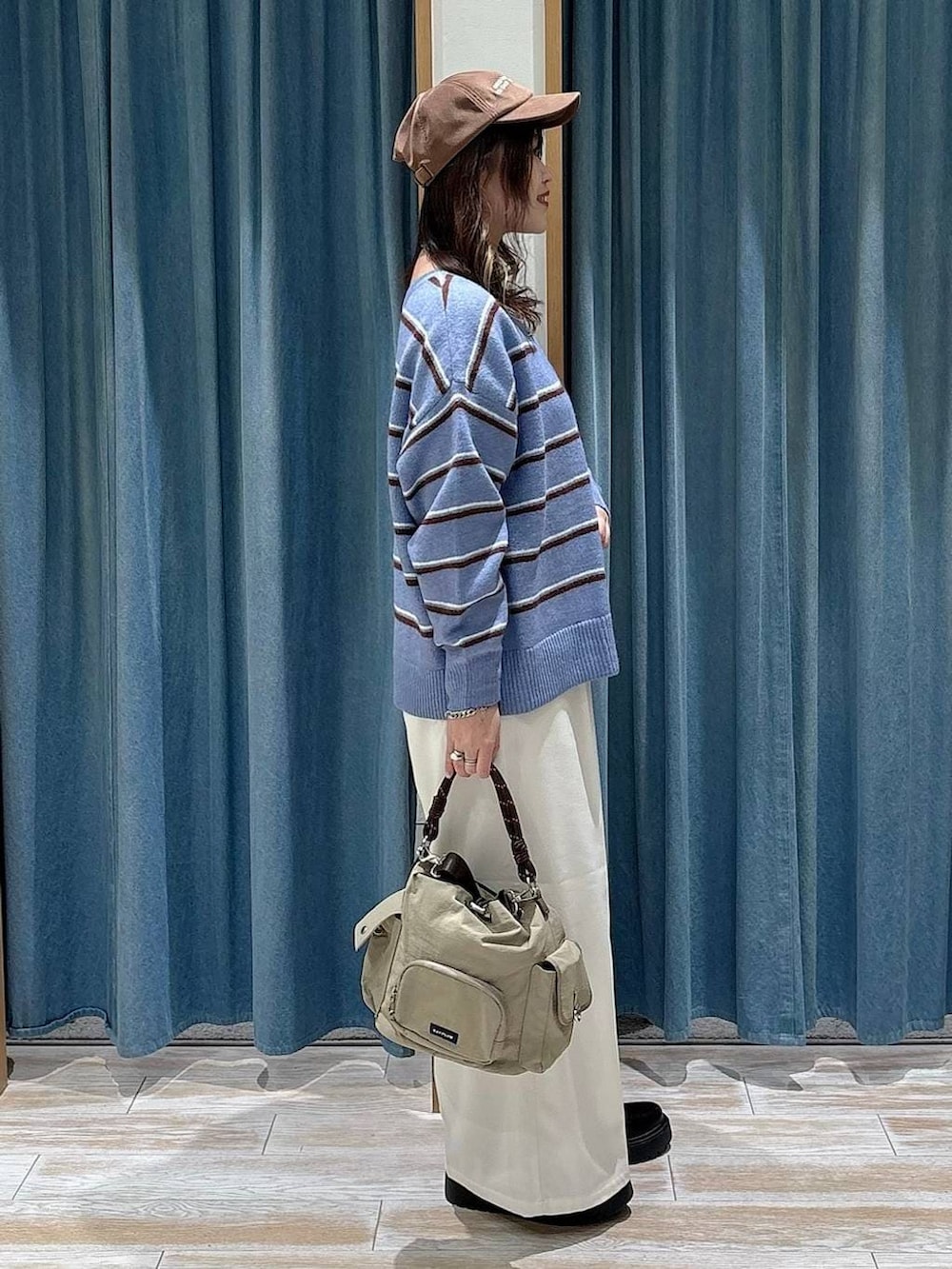 ベージュ系のその他パンツ、ブラック系のブーツ、ベージュ系のハンドバッグを着用したレディースの冬コーディネートの2枚目の写真