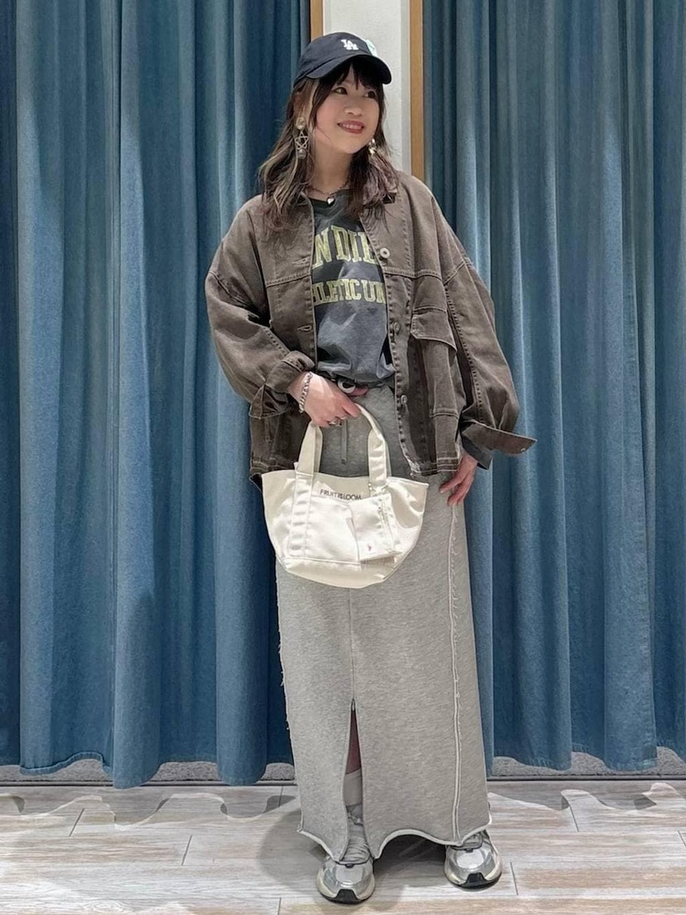 グレー系のTシャツ/カットソー、グレー系のスカート、ブラウン系のデニムジャケットを着用したレディースの春コーディネートの4枚目の写真