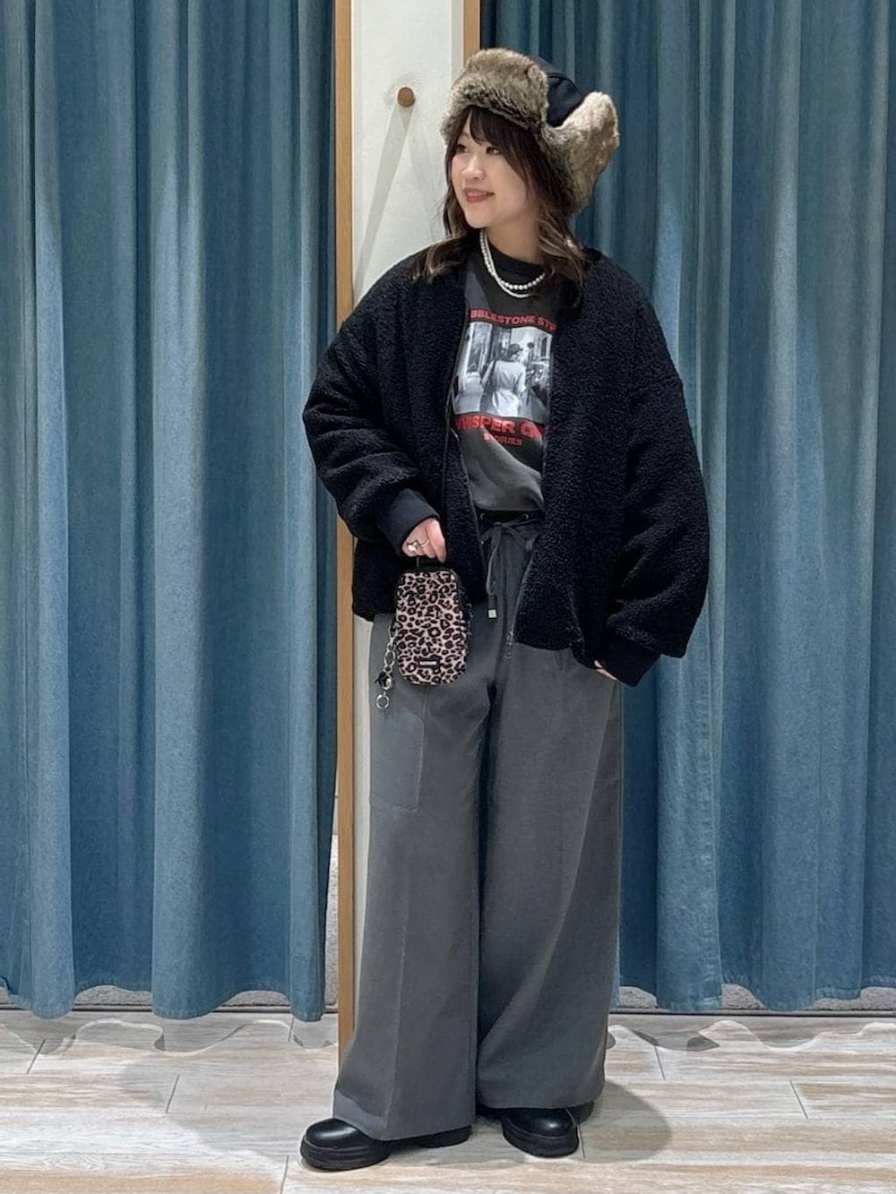 ブラウン系のショルダーバッグ、グレー系のその他パンツ、ブラック系のブルゾンを着用したレディースの冬コーディネートの3枚目の写真