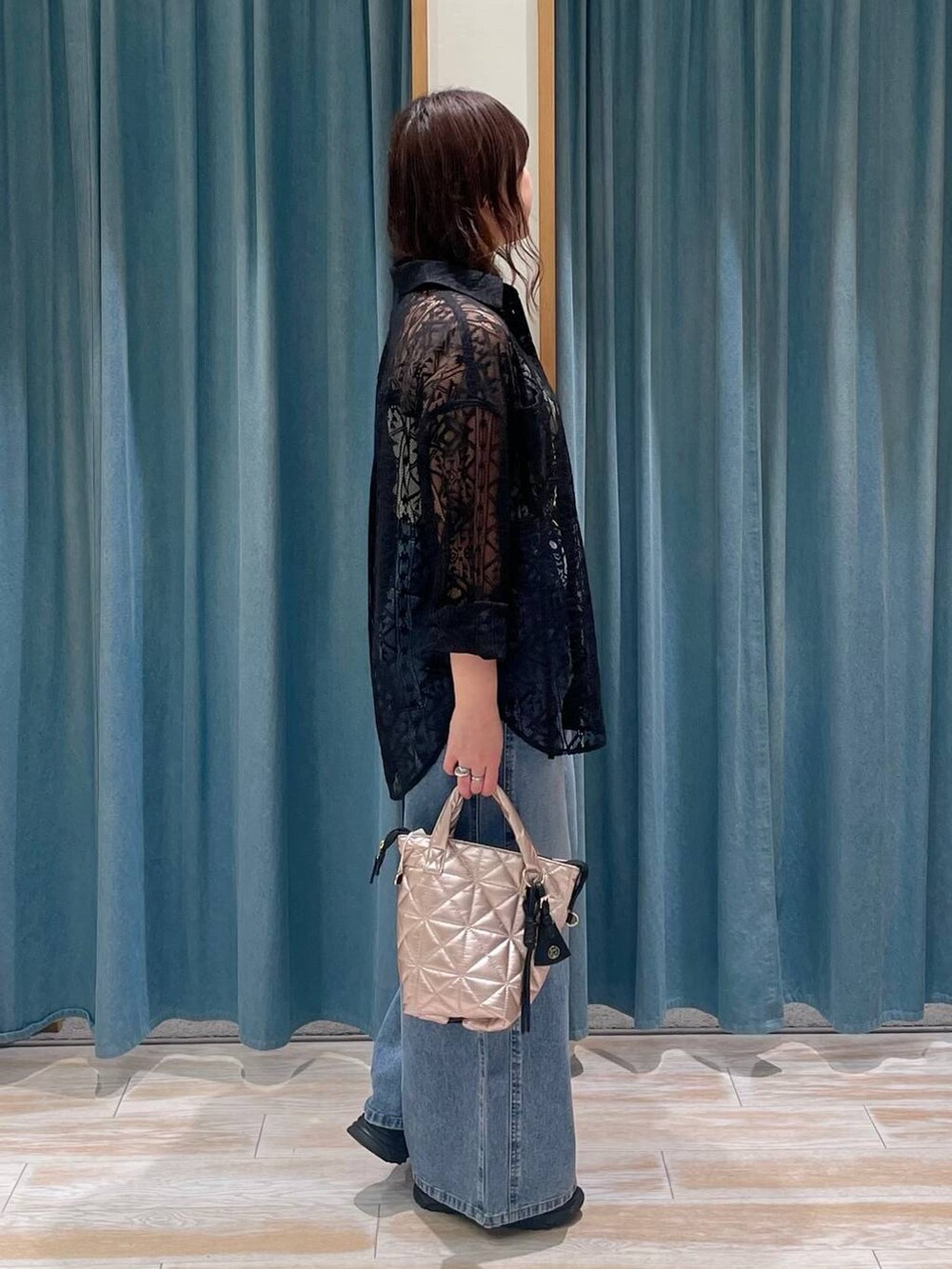 ホワイト系のキャミソール、ブルー系のデニムパンツ、ピンク系のハンドバッグを着用したレディースの春コーディネートの2枚目の写真