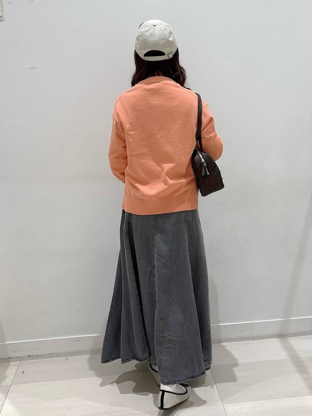 シルバー系のバレエシューズ、ホワイト系のTシャツ/カットソー、ブラック系のデニムスカートを着用したレディースの冬コーディネートの2枚目の写真