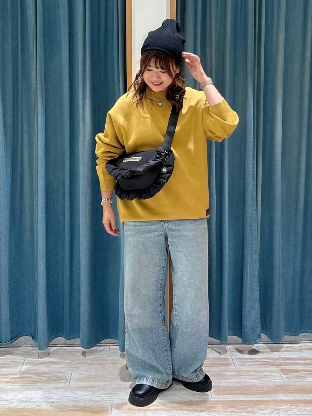 ブルー系のデニムパンツ、ブラック系のサンダル、ブラック系のショルダーバッグを着用したレディースの夏コーディネートの3枚目の写真