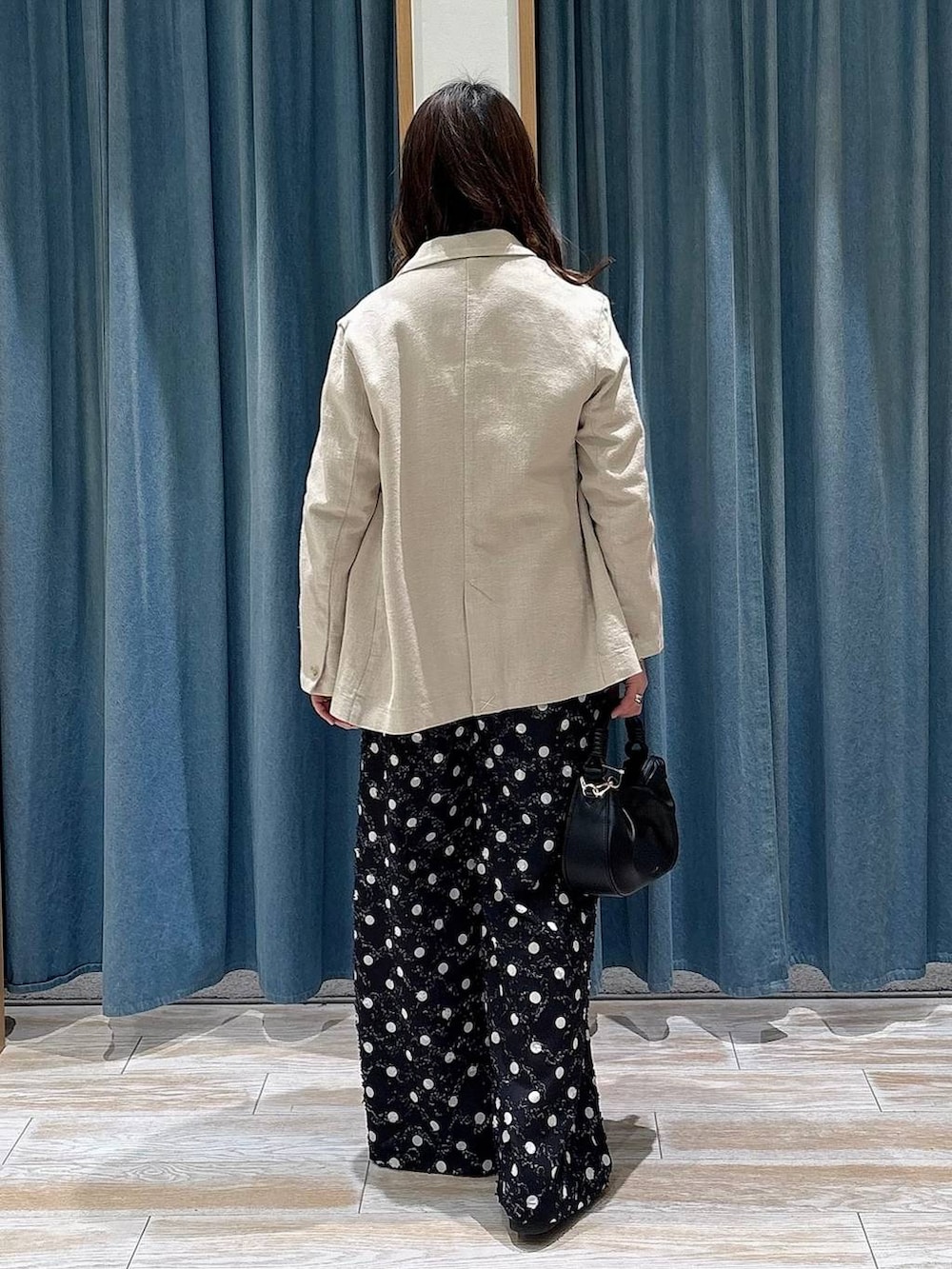 ブラック系のTシャツ/カットソー、ブラック系のハンドバッグ、ブラック系のローファーを着用したレディースの春コーディネートの3枚目の写真