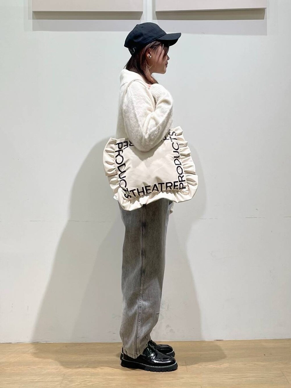 ブラック系のローファー、ブラック系のデニムパンツ、ベージュ系のトートバッグを着用したレディースの秋コーディネートの2枚目の写真