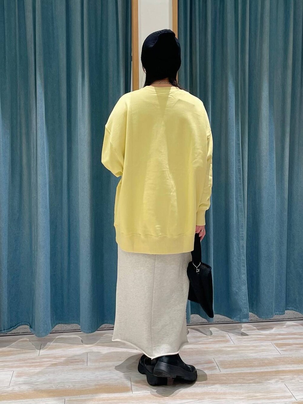 ブラック系のブーツ、イエロー系のスウェット、ベージュ系のスカートを着用したレディースの冬コーディネートの3枚目の写真