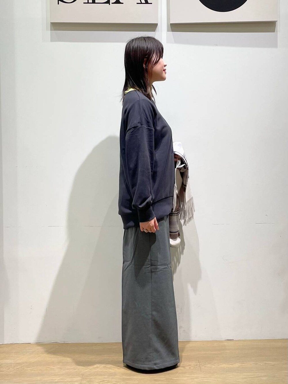 グリーン系のTシャツ/カットソー、ブラック系のブーツ、グレー系のその他パンツを着用したレディースの秋コーディネートの2枚目の写真