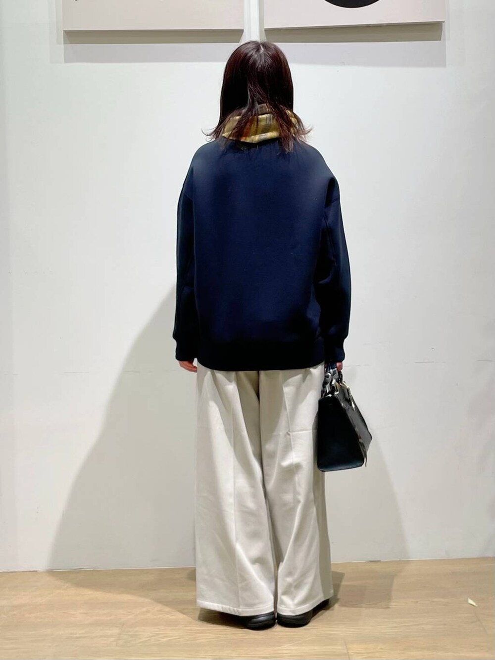 ブラック系のローファー、ブラック系のハンドバッグ、ホワイト系のその他パンツを着用したレディースの秋コーディネートの3枚目の写真