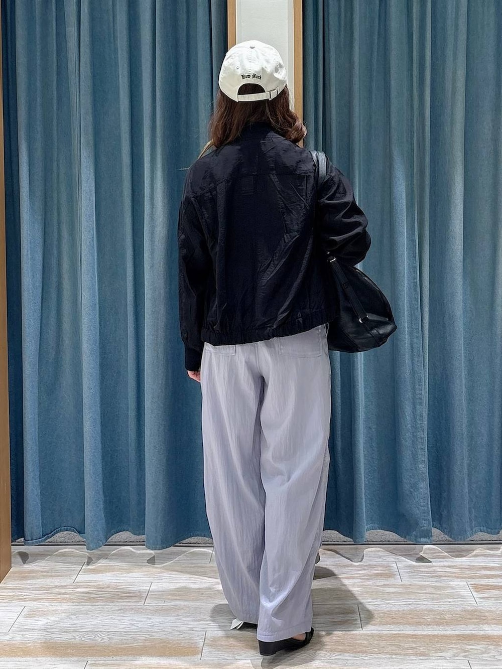 ブラック系のブルゾン、パープル系のその他パンツ、ブラック系のトートバッグを着用したレディースの春コーディネートの3枚目の写真